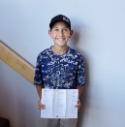 Youth Saver Caleb Isley holds up his report card