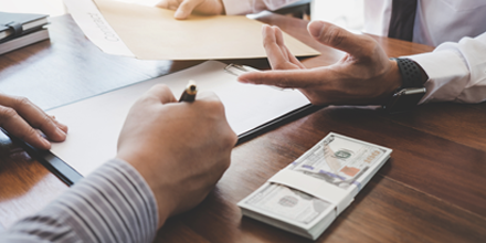 Man signing business form on table