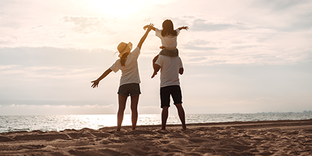 Family on beach looking at ocean. 