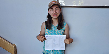 Youth saver, Madison Isley holds up her report card