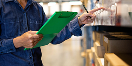 Man with green clipboard taking inventory