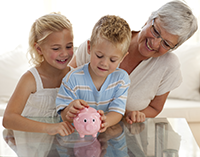 Grandma with grandson and granddaughter holding piggy bank. 