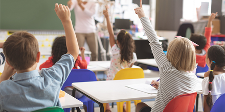 A Class of children raising their hands