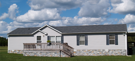 Gray trailer home with stone work