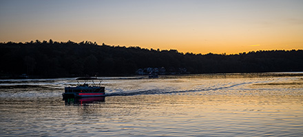 Pontoon boating in lake on a sunset cruise.