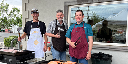 Joe Nelson, John Kasberger, and Shane Duncan grilling hamburgers and hot dogs at our 2023 BBQ in Hermiston. 